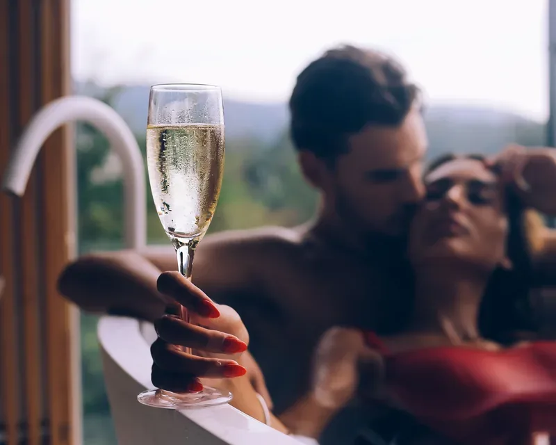 Bearded man kissing a woman in a red top, exotic outcall massage with bathtub in Zaragoza