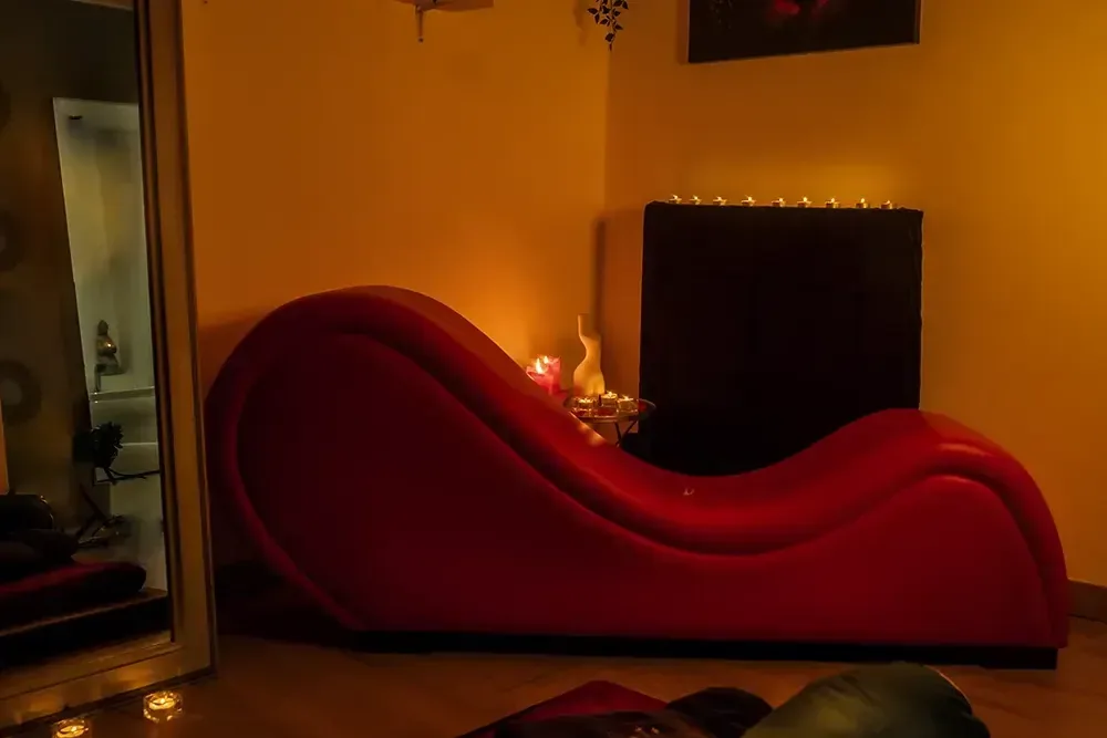 Un sofá tantra rojo de forma ondulada, masajista erótica independiente velas Zaragoza