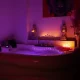 Habitación en penumbra con luz violeta y rojiza, precio masaje nuru habitación Zaragoza
