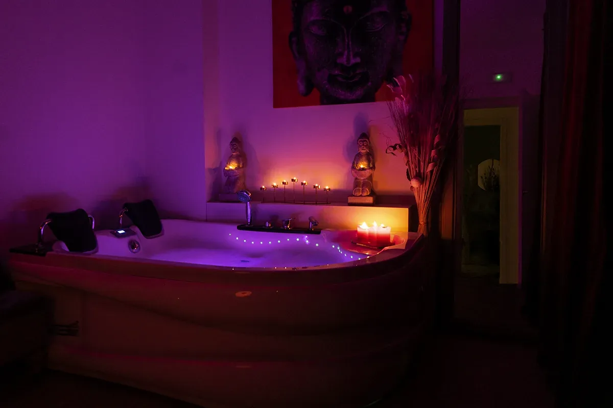 Bañera de hidromasaje grande con dos reposacabezas oscuros y puntos de luz LED, precio masaje tántrico reserva Zaragoza