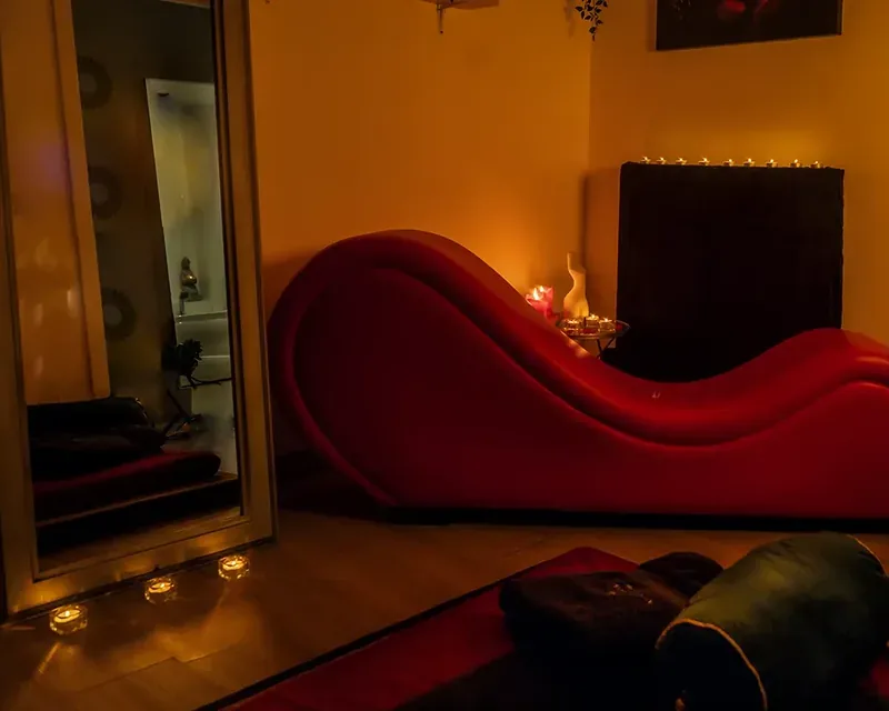 Red wave-shaped tantric sofa and a mirror by candlelight, relaxing Thai erotic in Zaragoza