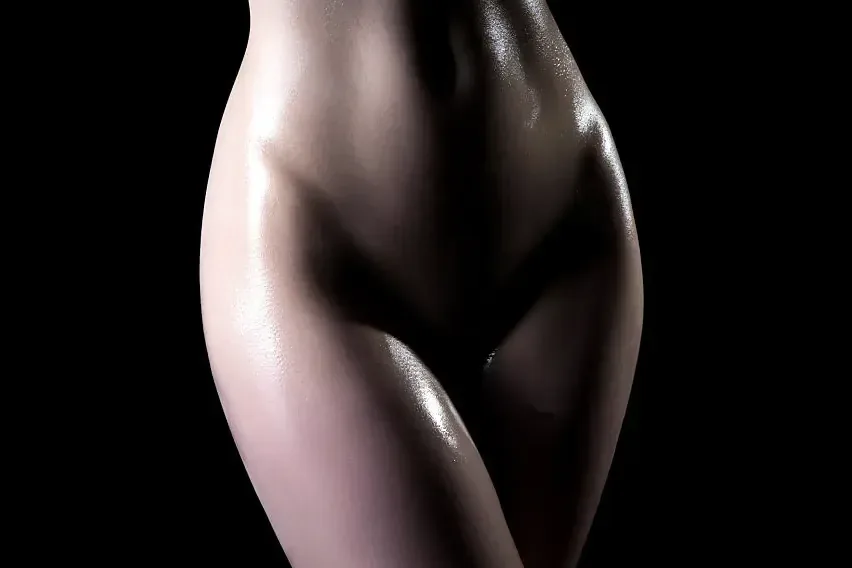 Close-up of the lower torso and hips of a bare body, tantra massage FAQ in Zaragoza